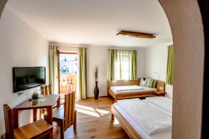 a living room with a bed and a couch at Pension Tannhof in Fuschl am See