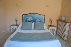 a bedroom with a bed with a blue headboard at Villa Valflor chambres d'hôtes et appartements in Marseille