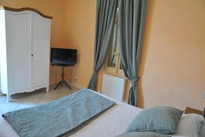 a bedroom with a bed and a television and curtains at Villa Valflor chambres d'hôtes et appartements in Marseille