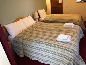a hotel room with two beds with towels on them at Pier House Bed & Breakfast in Inis Mor