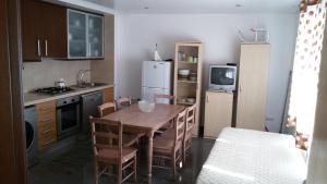 a kitchen with a table and chairs and a refrigerator at Casa Largo dos Cedros in Nazaré