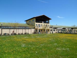 a large building with a grass field in front of it at Albergue De Peregrinos Santiago Apostol in Puente la Reina