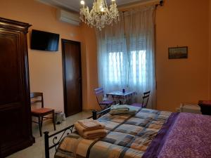 ローマにあるThe Sun Houseのベッドルーム1室(ベッド1台、テーブル、シャンデリア付)
