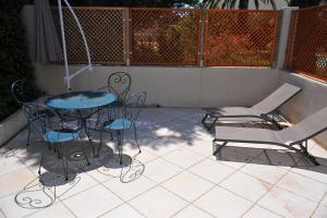 a patio with a table and chairs and a fence at Villa Valflor chambres d'hôtes et appartements in Marseille