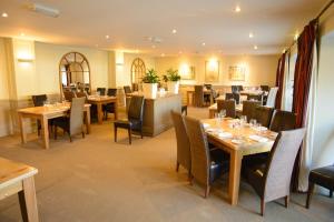 a restaurant with tables and chairs and a bar at The Kings Arms in Sherborne