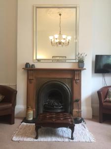 a living room with a fireplace with a mirror above it at Olympia W14 Two-Bedroom Apartment in London