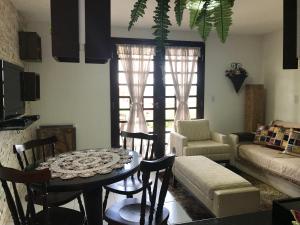 a living room with a table and chairs and a couch at Chalé no Condomínio Serra Nevada I in Bananeiras