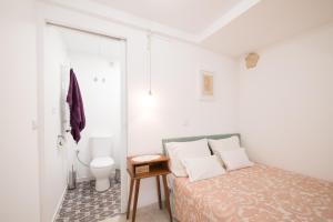 リスボンにあるLittle studio for two-Alfamaの白いベッドルーム(ベッド1台、トイレ付)