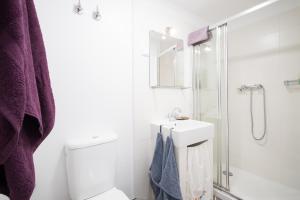 ein weißes Bad mit einem Waschbecken und einer Dusche in der Unterkunft Little studio for two-Alfama in Lissabon