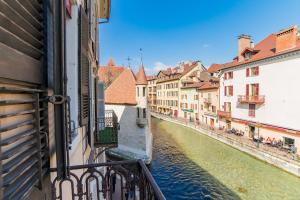 uma vista para um canal a partir de uma varanda numa cidade em Hôtel du Palais de l'Isle em Annecy