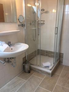 W łazience znajduje się prysznic i umywalka. w obiekcie Landgasthof Kirchmayer w mieście Farchant