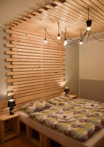 een slaapkamer met een groot bed en een houten muur bij Guest House Park Žibert in Ljubljana