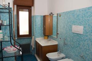 a blue tiled bathroom with a sink and a toilet at Sole e Luna in Pompei +15 photos