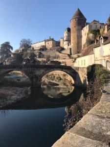 un pont sur une rivière en face d'un château dans l'établissement Etape du Pont Pinard, à Semur-en-Auxois