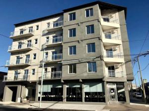 a tall apartment building with windows at Demetrio Hotel Apart in Olavarría
