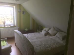 a bedroom with a white bed and a window at Haus Toquard in Wittmund