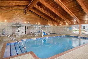 a large swimming pool in a large building with at AmericInn by Wyndham Anamosa in Anamosa