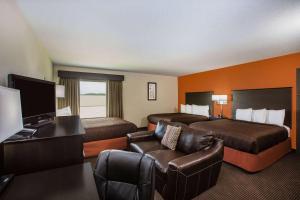 a hotel room with two beds and a desk at AmericInn by Wyndham Baxter Brainerd in Baxter