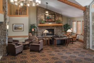 een woonkamer met meubilair en een open haard bij AmericInn by Wyndham Anamosa in Anamosa