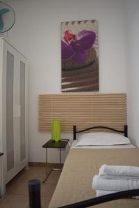 a bedroom with a bed and a painting on the wall at Paolina Rooms in Rome