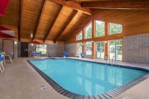 a large swimming pool in a building with a wooden ceiling at AmericInn by Wyndham Lake City in Lake City