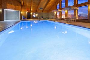a large swimming pool in a room with a table at AmericInn by Wyndham Rice Lake in Rice Lake