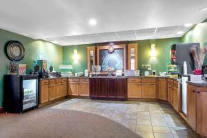 a large kitchen with wooden cabinets and a refrigerator at AmericInn by Wyndham Green Bay East in Green Bay