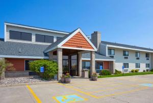 a building with a gazebo in a parking lot at AmericInn by Wyndham Spencer in Spencer