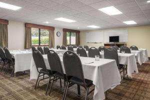 a conference room with white tables and chairs and a screen at AmericInn by Wyndham Lake City in Lake City +39 photos