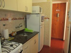 a kitchen with a white refrigerator and a sink at Cerca de Todo in Miramar +3 photos