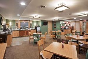 a restaurant with tables and chairs and a cafeteria at AmericInn by Wyndham Fort Pierre Conference Center in Fort Pierre