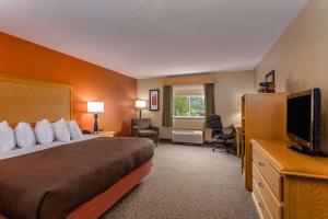 una habitación de hotel con una cama y un televisor en AmericInn by Wyndham Boscobel, en Boscobel