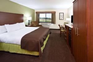 a hotel room with a bed and a desk at AmericInn by Wyndham Osage in Osage