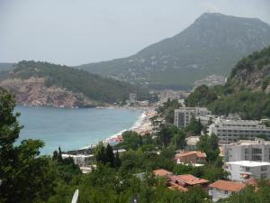 a view of a beach with buildings and a mountain at Apartmani CECA 012 Sutomore in Sutomore