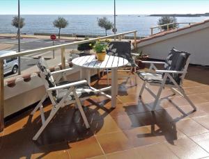 a table and two chairs on a balcony with the ocean at Appartement Les Gavines in L'Escala