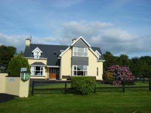 a large yellow house with a black roof at Ashfield B&B in Kenmare