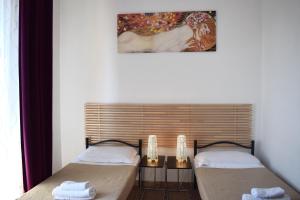 two beds sitting next to a window in a room at Paolina Rooms in Rome