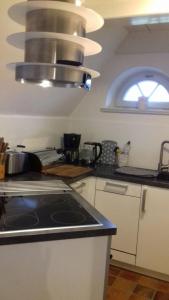 a kitchen with a stove top and a window at Das Rosenhaus in Utersum