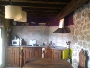 a kitchen with a table and a sink and a stove at La Dueña I in Miranda del Castañar +34 photos