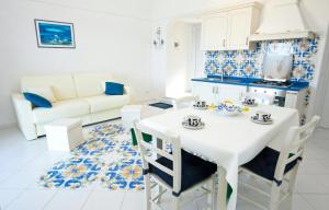 una cucina e un soggiorno con tavolo e sedie bianchi di Maridea - Magia di Circe a Ponza
