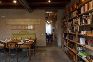 a dining room with a table and shelves of books at Corte Reginella in Roverbella