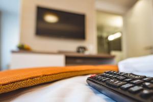 a remote control sitting on top of a bed at Oliver Apartments | contactless check-in in Vienna