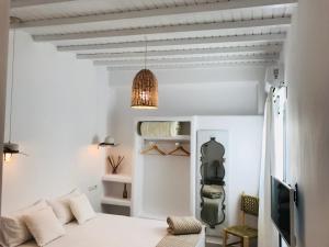 Habitación blanca con cama y sofá en Mykonos Unique Apartment, en Mykonos ciudad