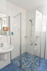 y baño con ducha y lavamanos. en Hotel Gästehaus Linden en Wolfenbüttel