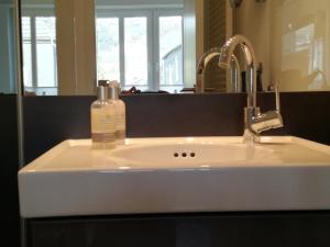 a bathroom sink with a soap bottle on it at Zimmer zum Hof in Herdecke