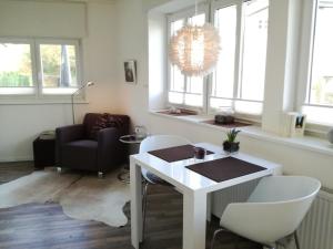 a living room with a table and chairs and a chandelier at Zimmer zum Hof in Herdecke