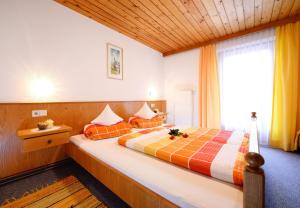 a bedroom with a large bed with orange pillows at Haus Renate in Kartitsch