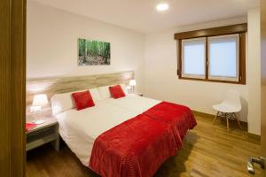 ein Schlafzimmer mit einem großen Bett mit einer roten Decke in der Unterkunft Ciudad de Orduña in Orduña