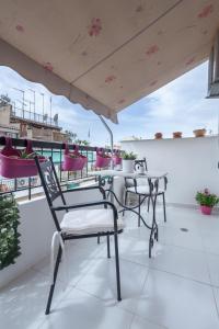 a patio with chairs and tables on a balcony at Athens charming flat 10 min away from Acropolis by metro in Athens
