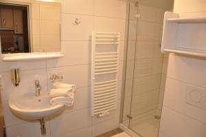 a white bathroom with a sink and a shower at Haus Renate in Kartitsch